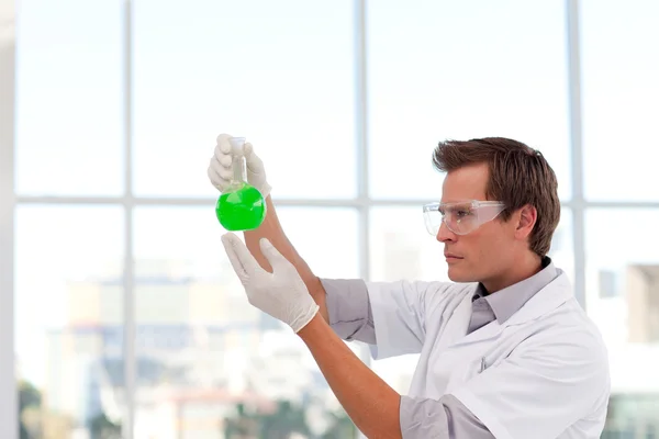 Seriöser Wissenschaftler untersucht ein chemisches Reagenzglas mit Kopierraum — Stockfoto