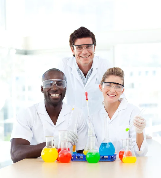 Cientistas sorridentes examinando tubos de ensaio — Fotografia de Stock