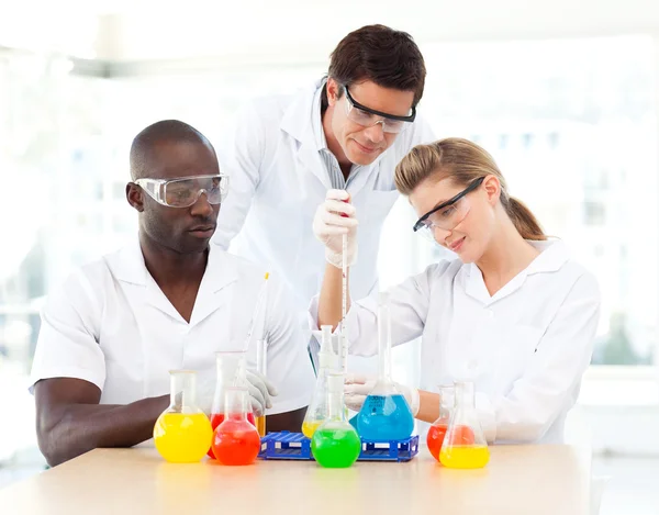 Jovens cientistas que examinam tubos de ensaio — Fotografia de Stock
