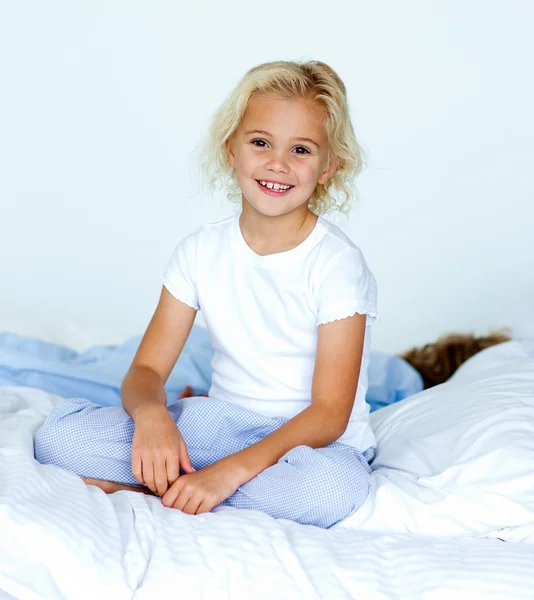 Kis lány az ágyban, mosolyogva a kamera, míg a bátyja sl — Stock Fotó