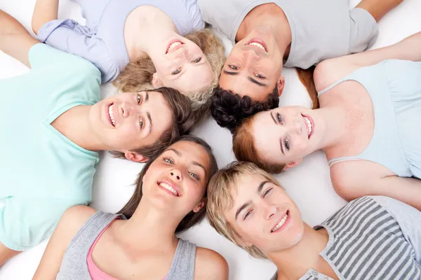 Tieners liggend op de vloer met hoofden samen — Stockfoto