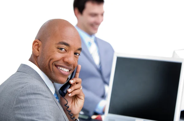 Szczęśliwy biznesmen na telefon i jego kolega pracuje w komput — Zdjęcie stockowe
