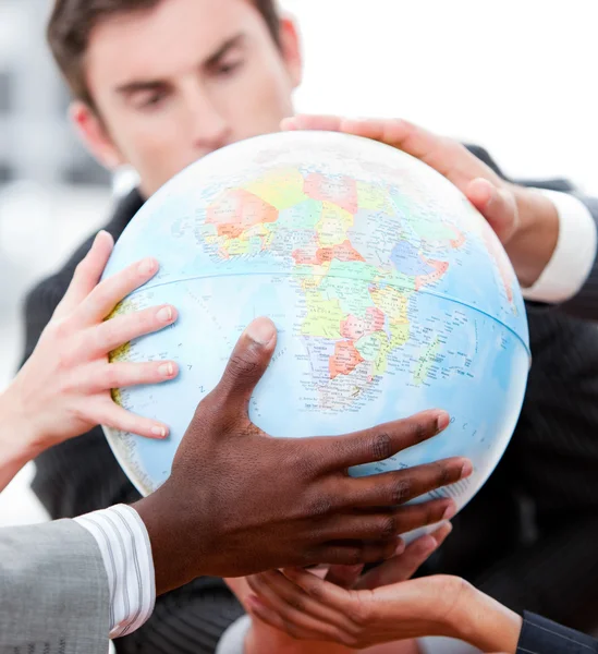 Närbild av en business-laget som innehar en terrestrial globe — Stockfoto