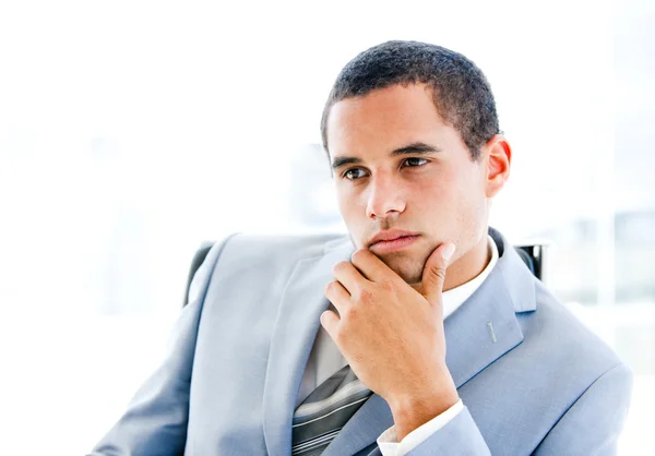 Портрет задумчивого молодого бизнесмена, сидящего за столом — стоковое фото