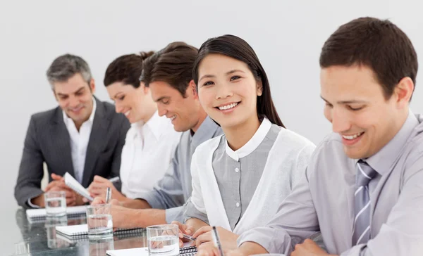 Parceiros de negócios sorridentes tomando notas em uma reunião — Fotografia de Stock