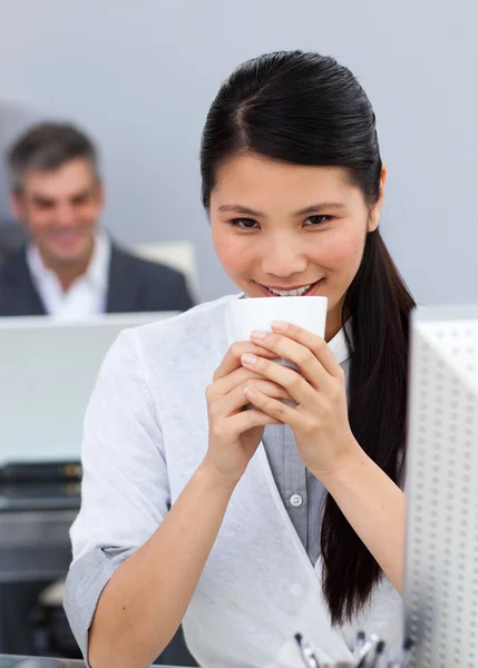 Lachende vertrouwen zakenvrouw drinken een kopje koffie op haar Bureau — Stockfoto