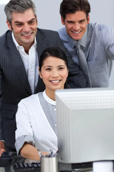 Parceiros de negócios sorridentes trabalhando juntos em um computador — Fotografia de Stock