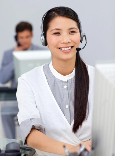 Усміхнена бізнес-леді з гарнітурою на комп'ютері — стокове фото