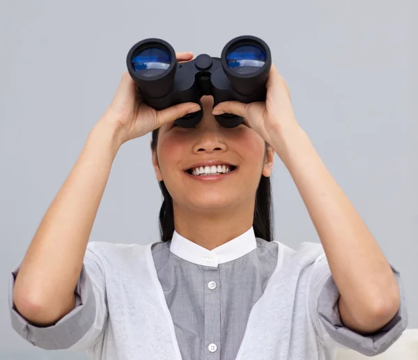 Visionary asian businesswoman looking through binoculars — Stock Photo, Image