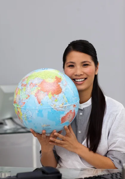 Уверенная азиатская предпринимательница, держащая земной шар — стоковое фото