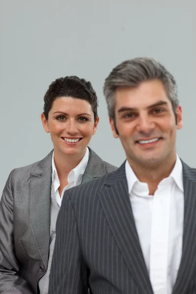 Бизнесмен и бизнесмен улыбаются в камеру — стоковое фото