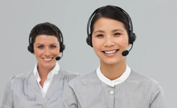 Twee aantrekkelijke vrouwelijke ondernemers met hoofdtelefoon op — Stockfoto
