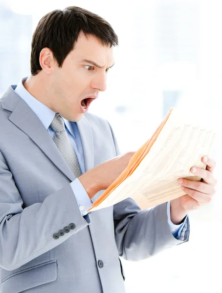 Retrato de um empresário surpreso lendo um jornal — Fotografia de Stock