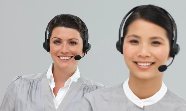 Lachende jonge vrouwelijke ondernemers met hoofdtelefoon op — Stockfoto