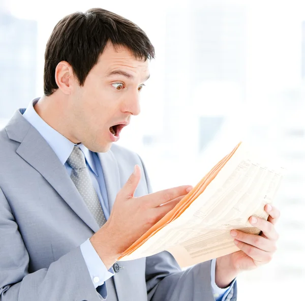 Portrait of a exited businessman reading a newspaper — Stock Photo, Image