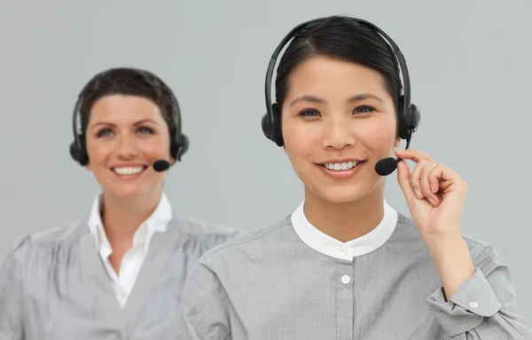 Kvinnliga kundtjänstagenter med hörlurarna på — Stockfoto
