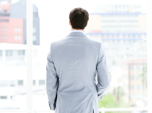 Ambitious businessman looking through a window — Stock Photo, Image