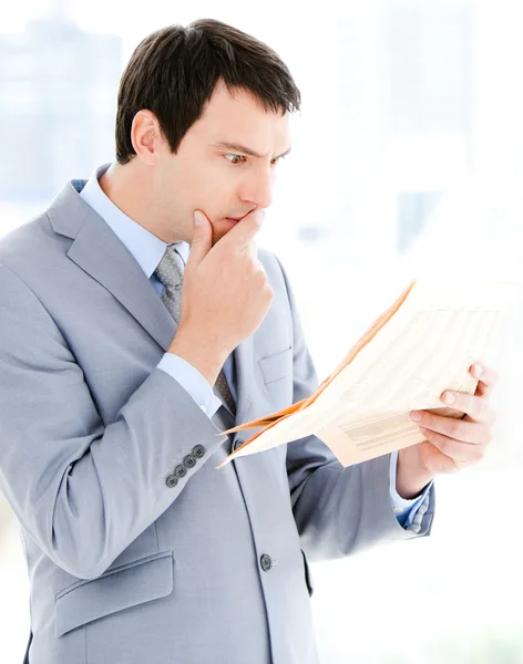 Portrait of a thinking businessman reading a newspaper — Stock Photo, Image