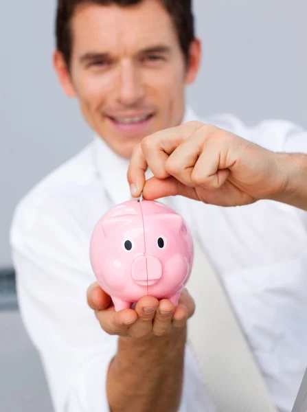 Atractivo hombre de negocios ahorrando dinero en una hucha — Foto de Stock
