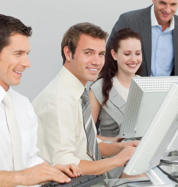 Empresario y sus colegas que trabajan con computadoras en una oficina — Foto de Stock