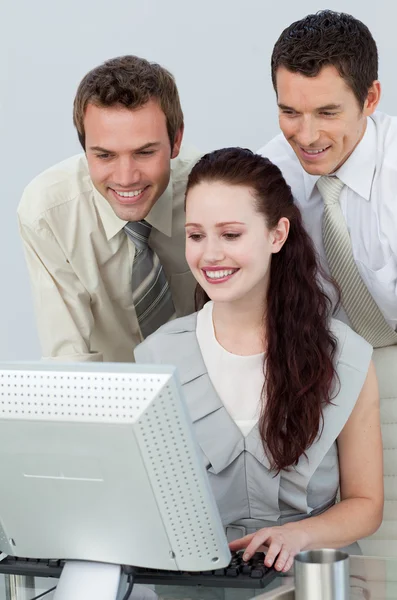 Geschäftsleute helfen einer Geschäftsfrau mit einem Computer — Stockfoto