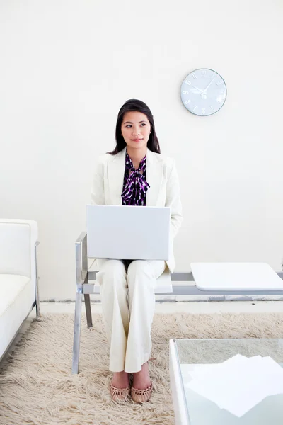 Vrouw die werkt op een laptop in een wiating kamer — Stockfoto