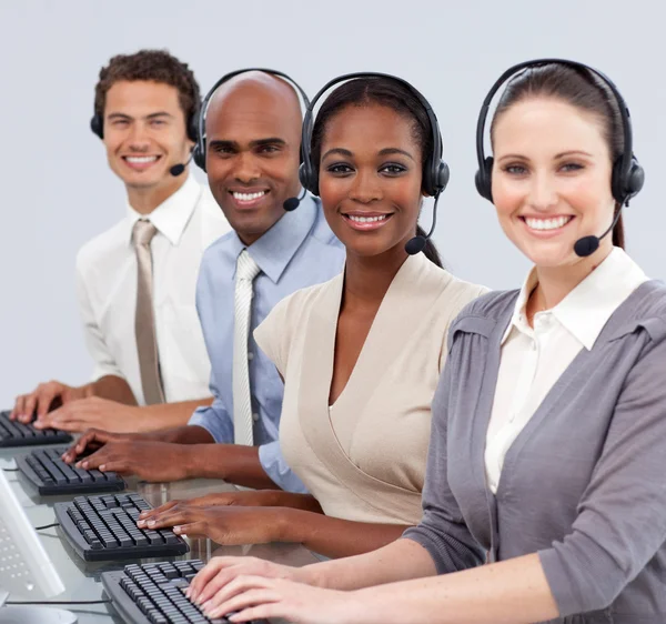 Multietniska affärer med hörlurarna på i ett callcenter — Stockfoto