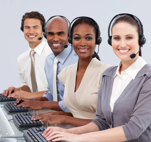 Negocios multiétnicos con auriculares en un centro de llamadas — Foto de Stock