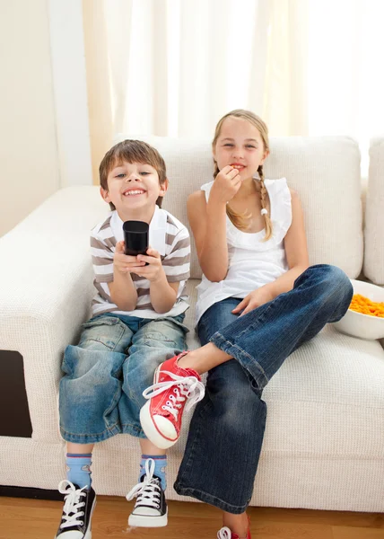 Glada syskon tittar på tv — Stockfoto
