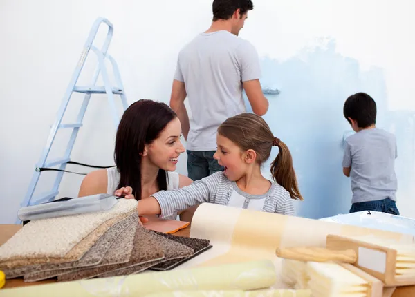 Lachende familie verfraaien van hun nieuwe huis — Stockfoto