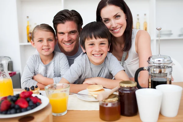 Leende familj äter frukost tillsammans — Stockfoto