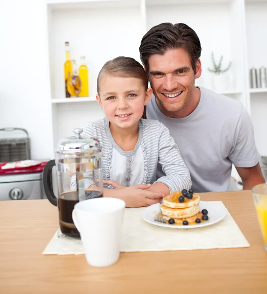 Retrato de um pai sorridente e sua filha tomando café da manhã — Fotografia de Stock