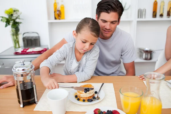 Kleines Mädchen isst Pfannkuchen mit ihrem Vater — Stockfoto