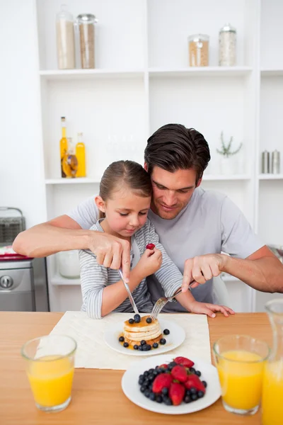 Portrait of a father eating pancakes with his daughter — Stock Photo, Image