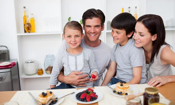 Fiatal család eszik gyümölcsöt és palacsintát reggelire — Stock Fotó