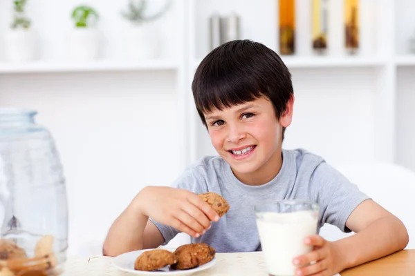 Усміхнений хлопчик їсть печиво — стокове фото
