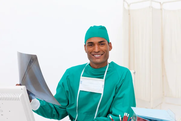 Smiling surgeon analyzing an x-ray — Stock Photo, Image