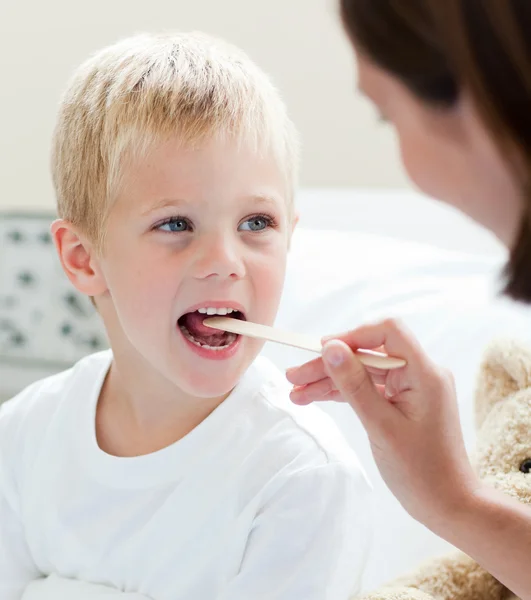 Um médico examinando a garganta de uma criança — Fotografia de Stock