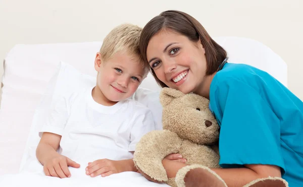 Smiling female doctor with her patient holding a teddy bear — Stock Photo, Image