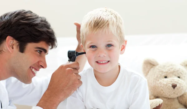 Atractivo médico revisando los oídos de su paciente — Foto de Stock