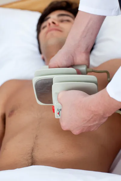 Bir doktor bir defibrilasyon hazırlanıyor — Stok fotoğraf