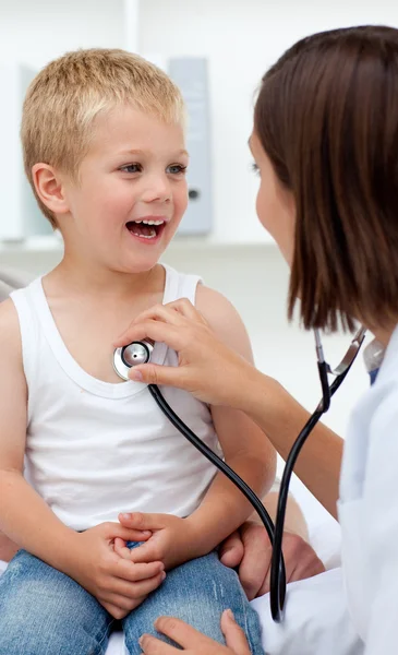 Ein Arzt überprüft den Puls eines lächelnden kleinen Jungen — Stockfoto