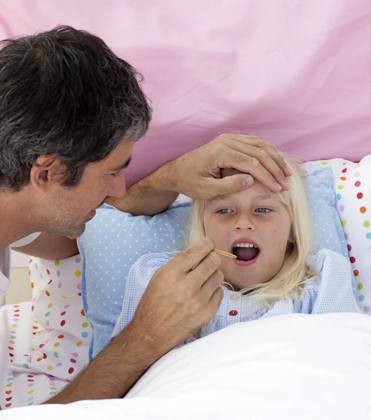 Padre tomando la temperatura de su hija con un termómetro — Foto de Stock