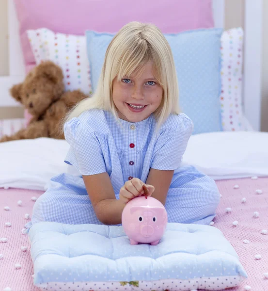 Uśmiechnięte dziewczyny oszczędności w piggy bank — Zdjęcie stockowe