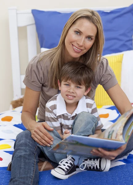 Привлекательная мать читает книгу со своим сыном — стоковое фото