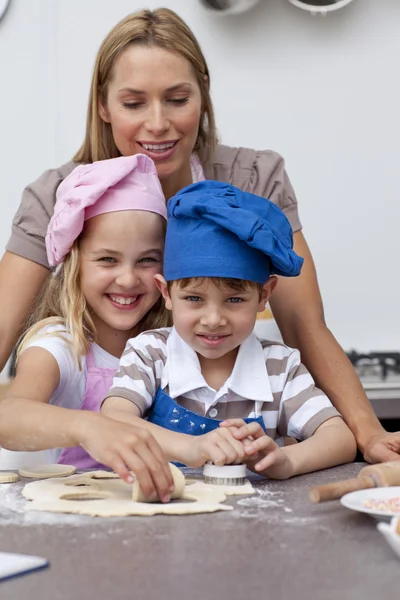 Madre aiutare i suoi figli cottura — Foto Stock