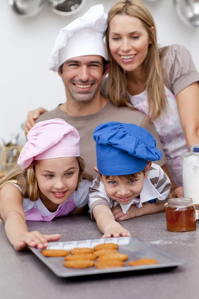 Family eating cookies after baking — Stock Photo, Image