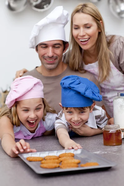 Kinder und Eltern essen nach dem Backen Plätzchen — Stockfoto