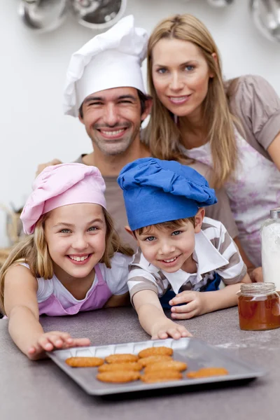 Happy children and parents eating cookies after baking — Stock Photo, Image