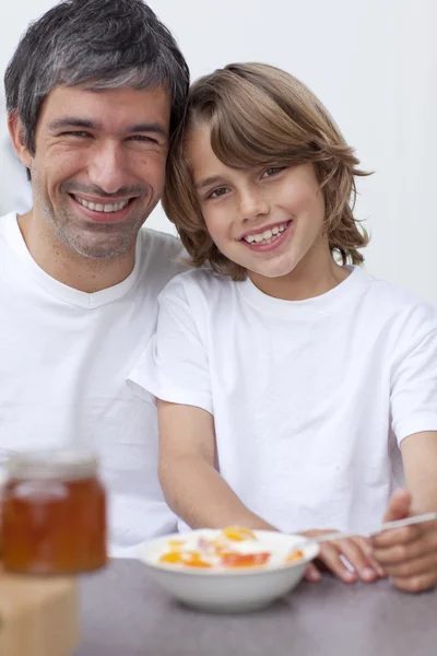 Porträtt av pappa och son äter frukost tillsammans — Stockfoto